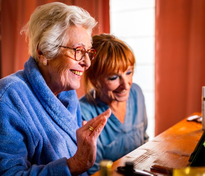 Senior en thuishulp videobellen met familie