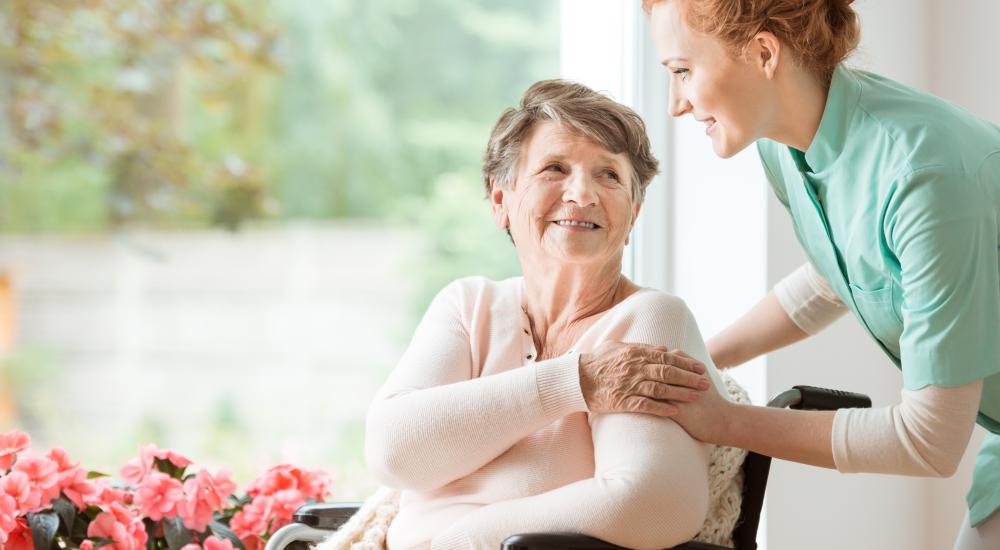 Senior met verzorgster