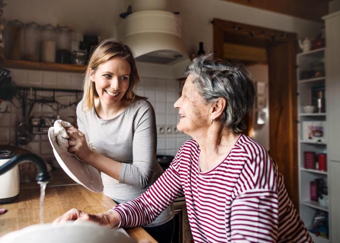 Senior en thuishulp in de keuken