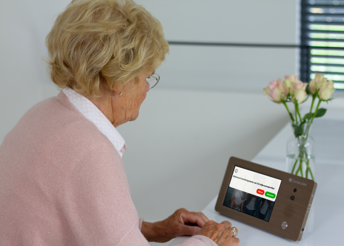 Mevrouw kijkt naar Genus met inkomend beeldgesprek