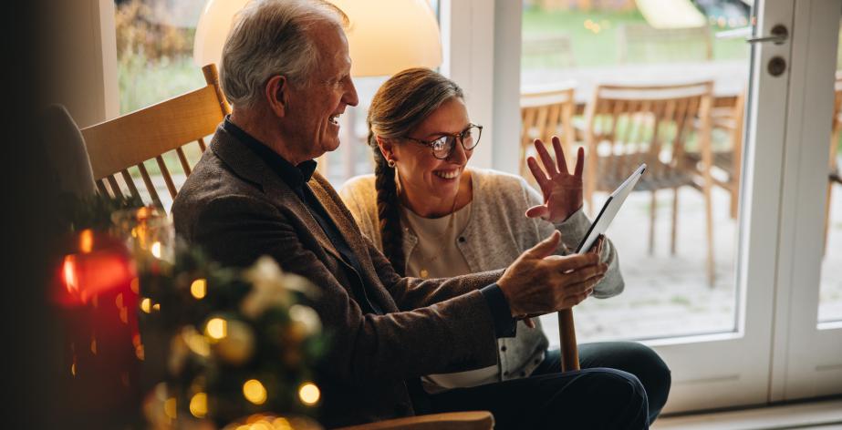 Senior en thuishulp bij de kerstboom